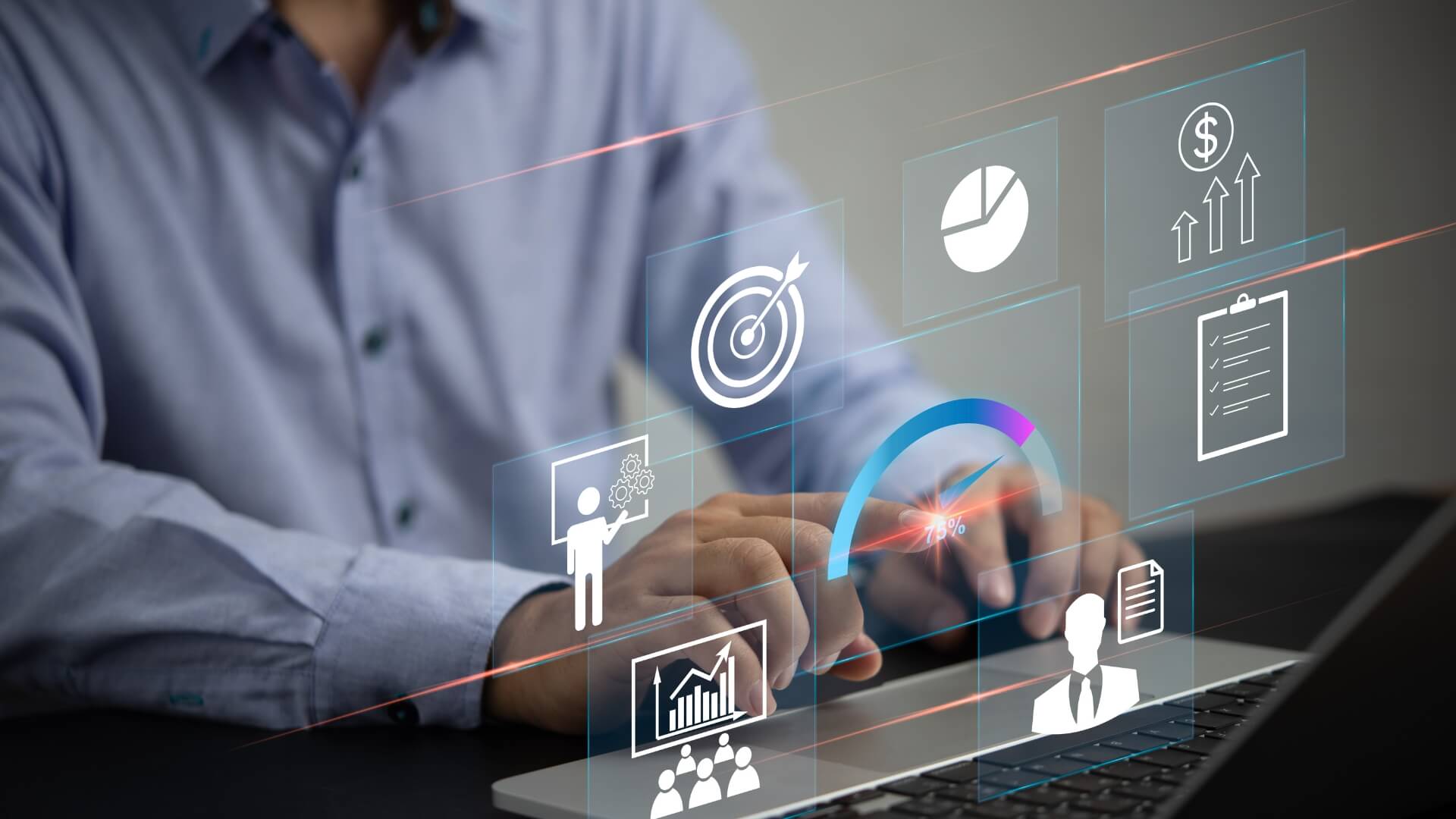 A person in a blue shirt interacts with a futuristic holographic interface projected from a laptop. The hologram displays various business performance analytics icons, including graphs, targets, and human figures.